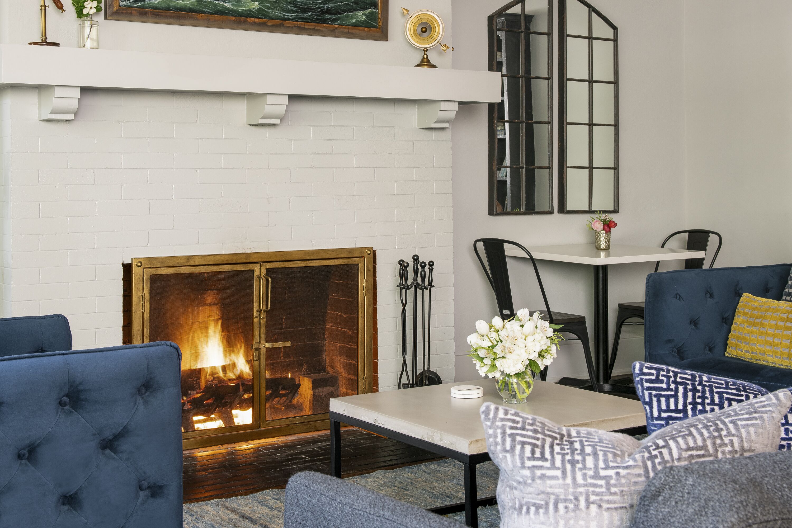 A cozy living room with a fireplace, comfortable seating, and a dining area.