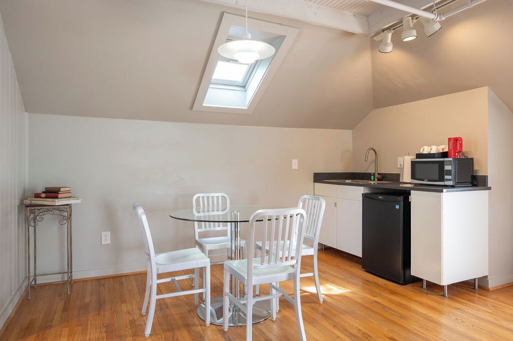 A compact kitchen with a dining area, a small side table, and a built-in microwave.