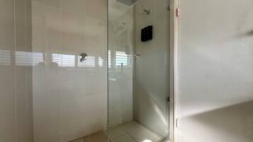 A glass-enclosed shower with a modern design, a visible showerhead, and a control panel on the wall.