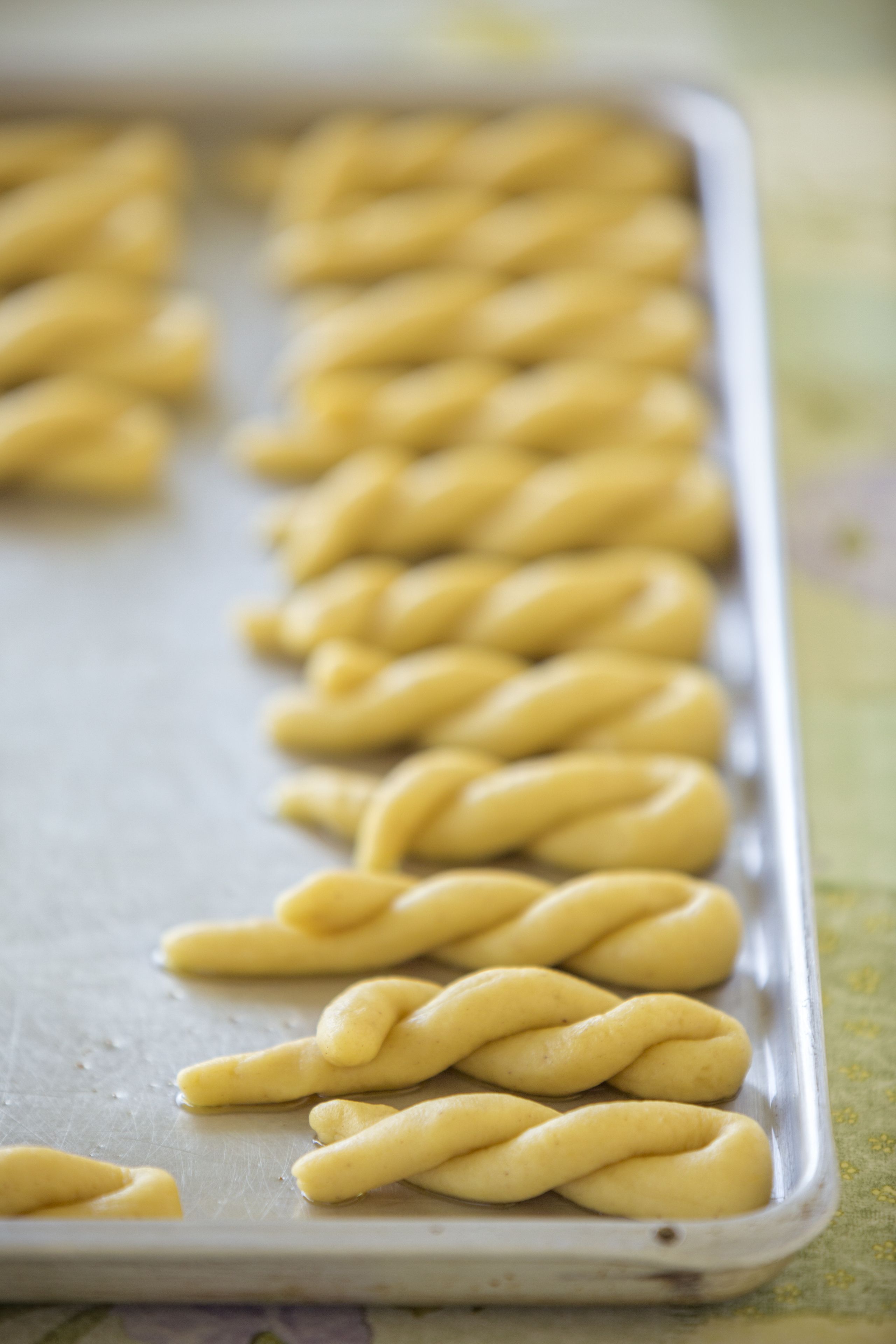 A tray of twisted dough shapes on a baking sheet.