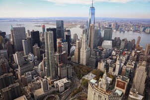 Een hoge skyline met een opvallend hoog gebouw, veel stedelijke gebouwen en een rivier.