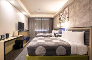 A hotel room with two beds, a desk, a television, and a large window with curtains. - Leon Hotel LES (New York)