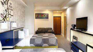 A modern hotel room with a large bed, a desk, a television, and a wardrobe.