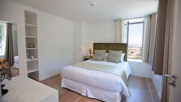 Ein Schlafzimmer mit einem großen Bett, einem Kleiderschrank und einem Fenster mit Vorhängen.