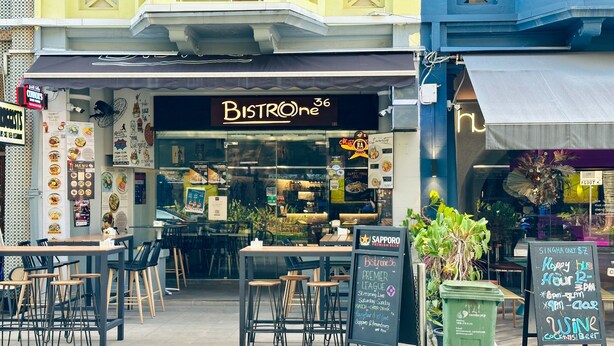 An outdoor seating area with tables and chairs in front of Bistro 36. - Rucksack Inn Tyrwhitt Road (Singapore)