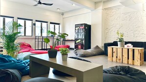 A modern living room with a sofa, a coffee table, and a bookshelf. - Rucksack Inn Tyrwhitt Road (Singapore)