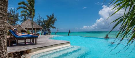 Piscine extérieure, parasols de plage, chaises longues