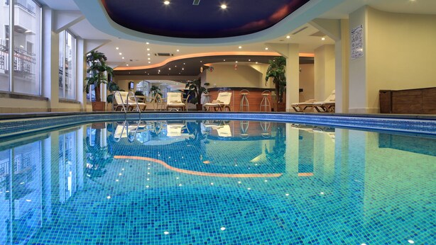 An indoor swimming pool with clear blue water, lounge chairs, and potted plants around the pool area. - Rescate Boutique Hotel Ankara (Ankara)