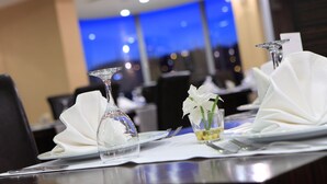 A dining table set with white napkins, clear glassware, and a small glass with a flower. - Rescate Boutique Hotel Ankara (Ankara)
