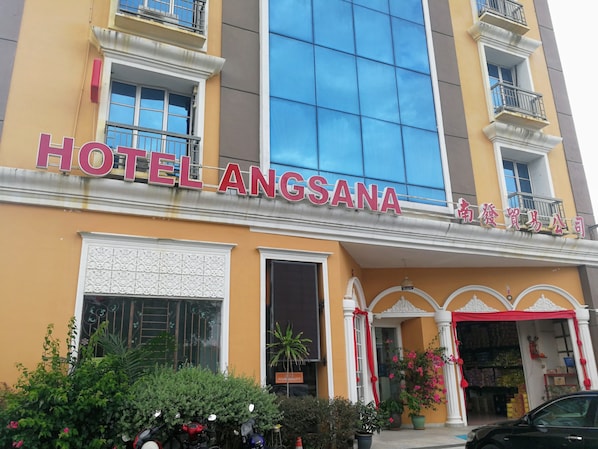 A hotel with a sign reading "HOTEL ANGSA" and a storefront with a sign in a foreign language.