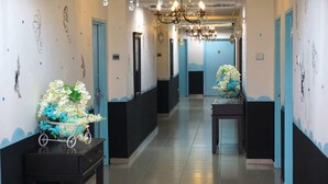 Et hotelkøkken med en lysekrone, blomsterarrangementer på borde og blå og hvide dekorationer.