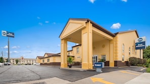 Welcome to the hotel, where a covered walkway leads to the main entrance, flanked by two wings.
