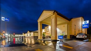 A Best Western hotel with a covered entrance, a wet parking lot, and multiple cars parked outside. - Best Western Inn (Elyria)