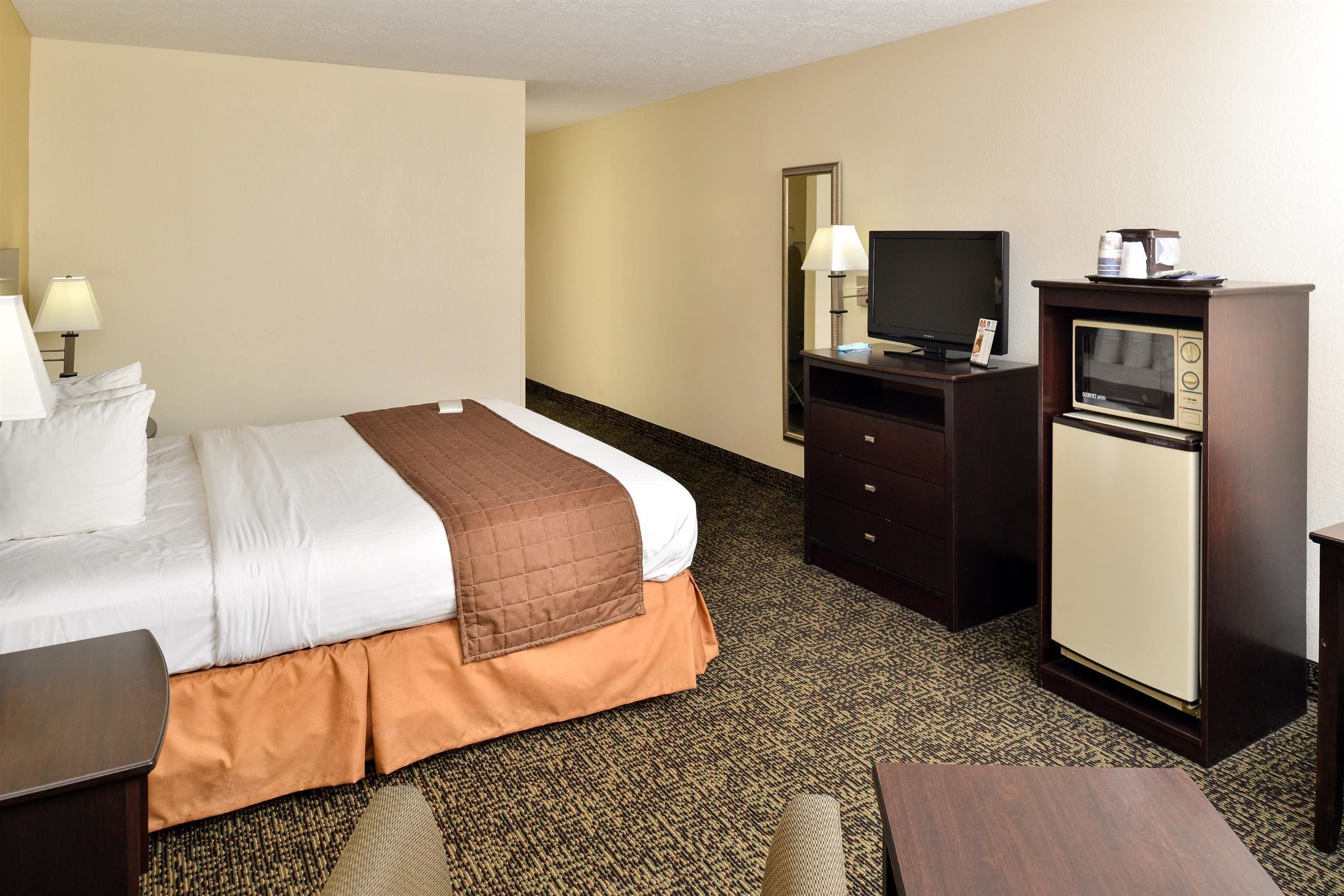 Une chambre d’hôtel équipée d’un lit, d’une télévision, d’un minibar et d’un bureau.