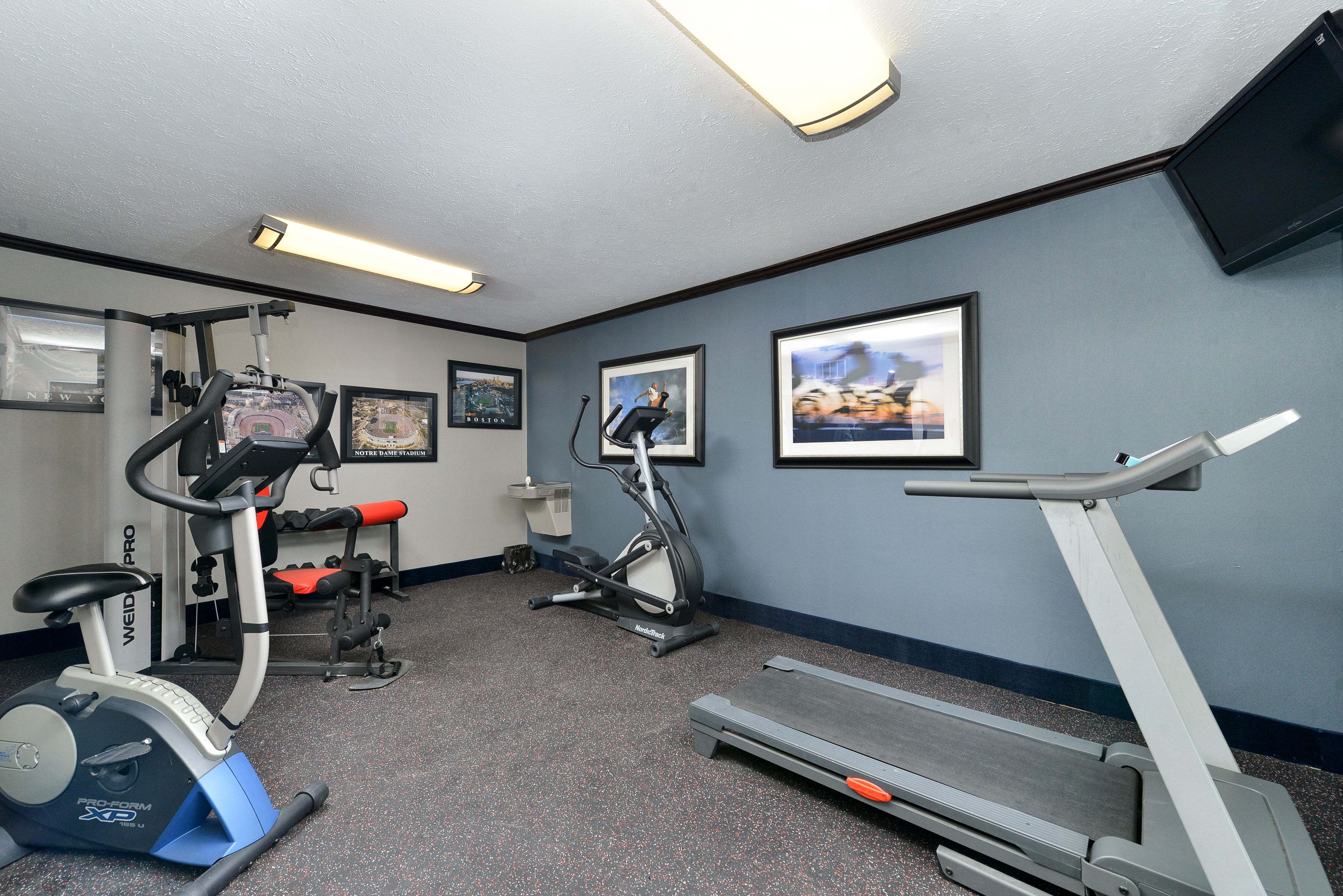 A fitness room with a treadmill, elliptical, and stationary bike.