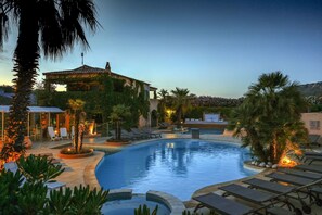 Una piscina al aire libre de temporada, tumbonas