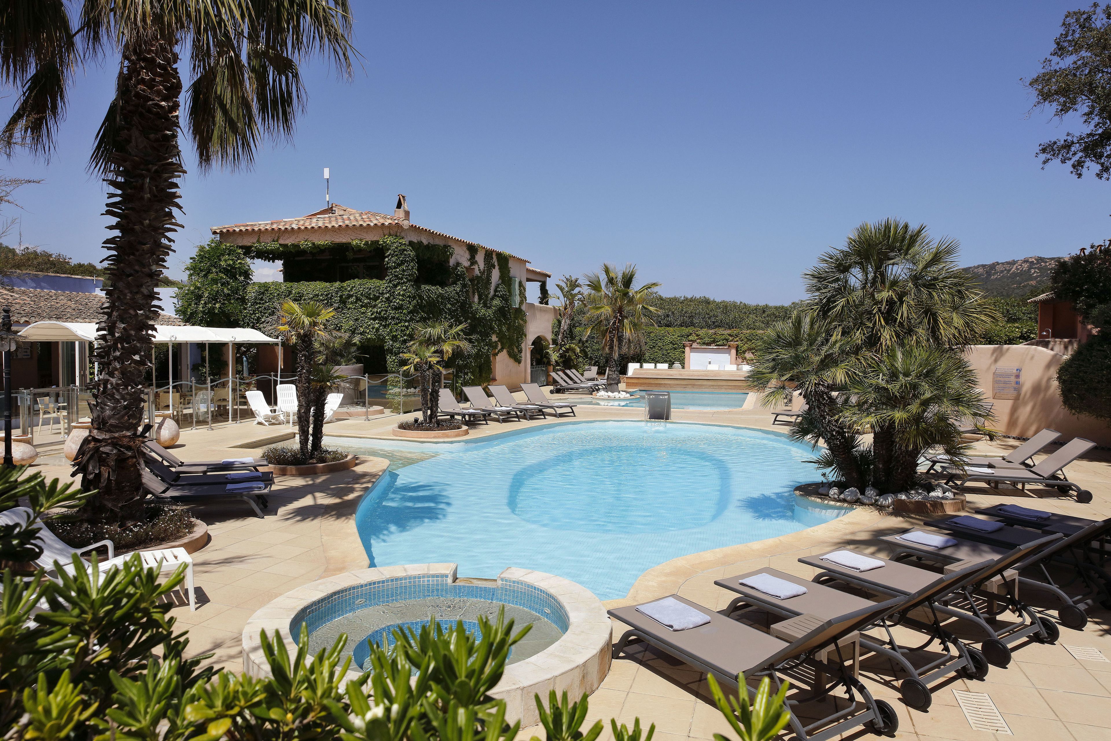 Zona de piscina con sillas de descanso y jacuzzi.
