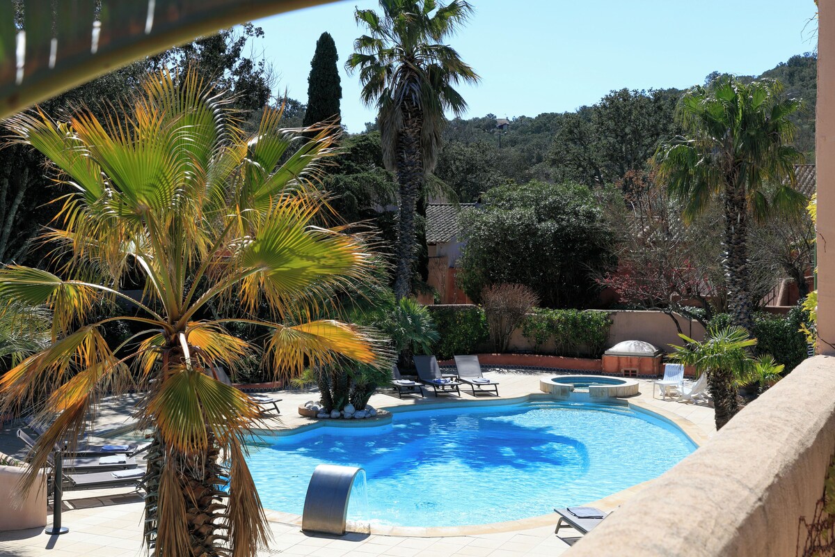 Une piscine avec des chaises longues et des palmiers.
