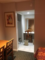 Escritorio, cortinas blackout y tabla de planchar con plancha