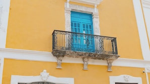 A building with a yellow facade, a blue window, and a sign that reads 'Plaza Galindo Hotel'. - Hotel Plaza Colonial (Campeche)