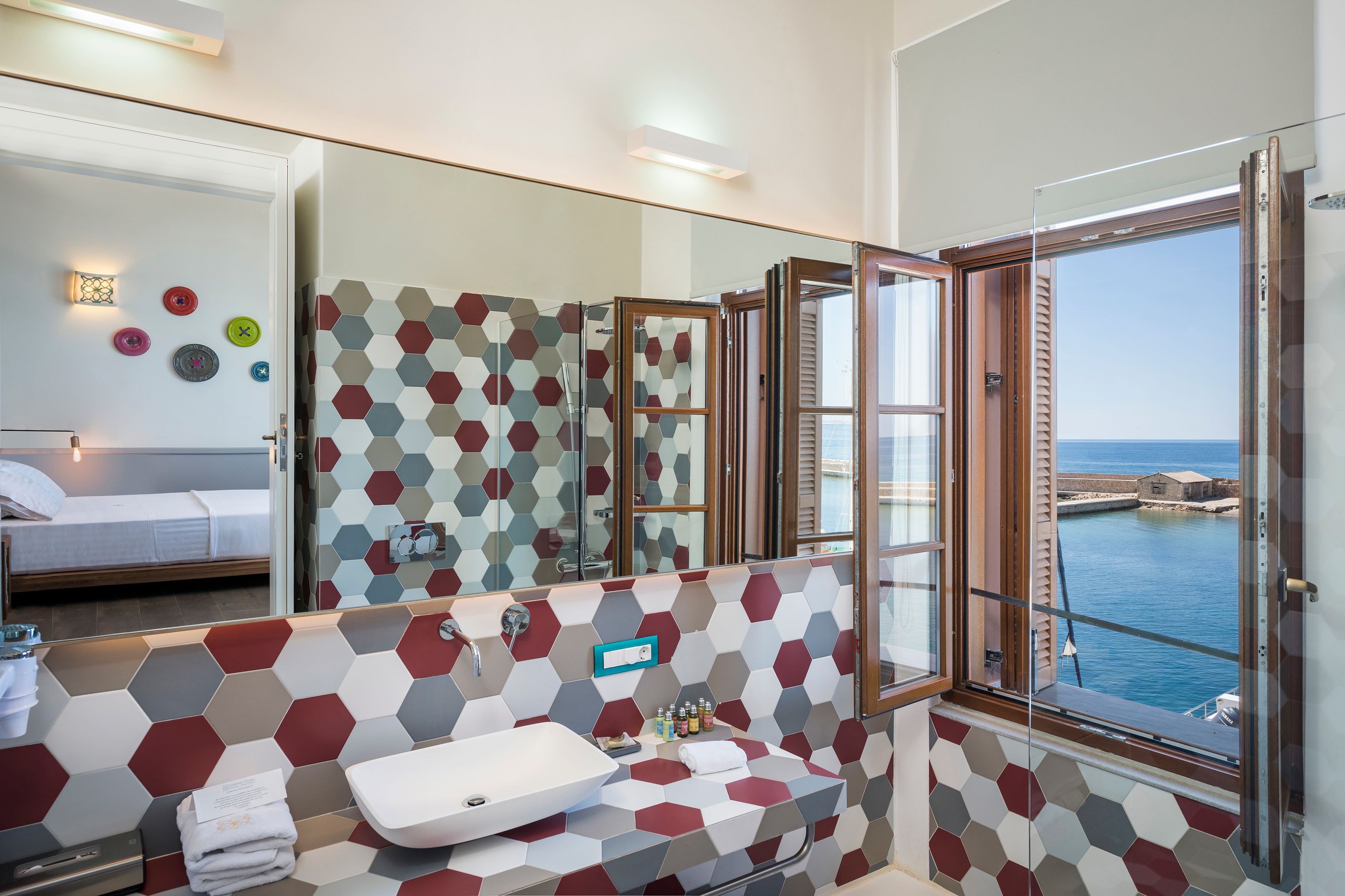 A modern bathroom with a large mirror, a sink, and a shower area.