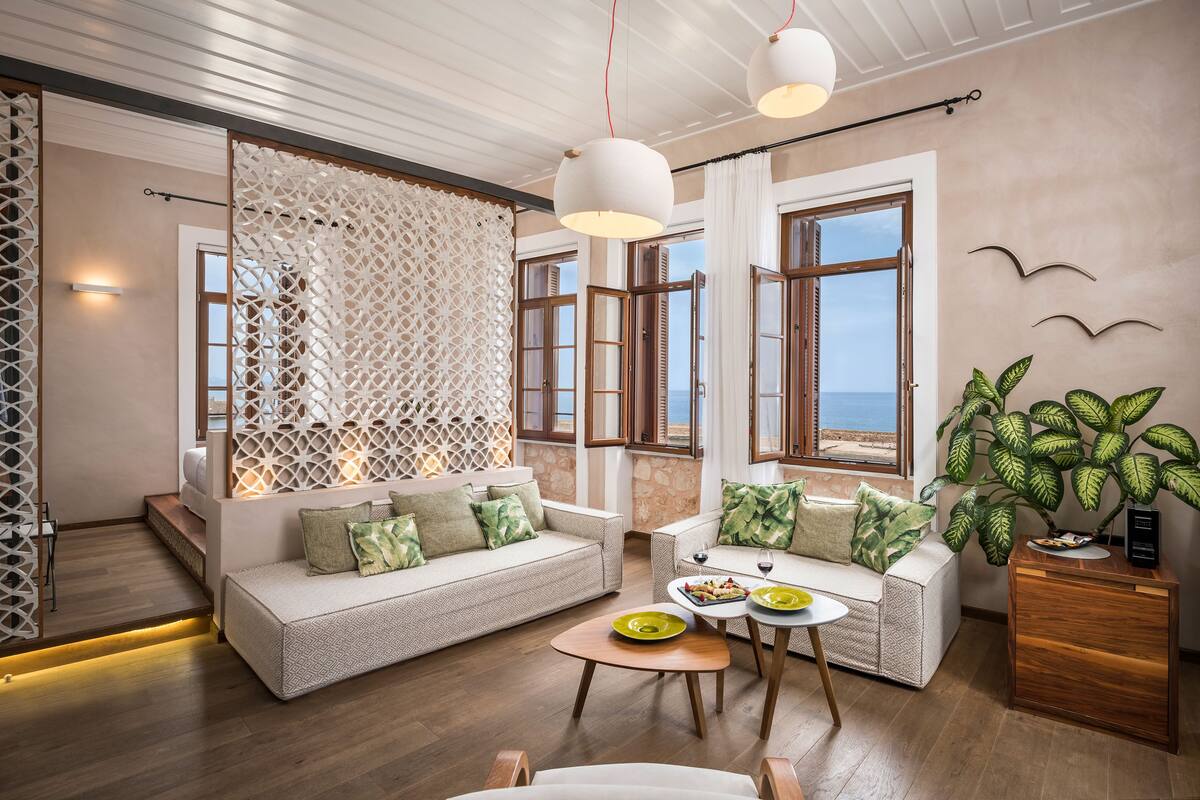A spacious living room with a sofa set, a coffee table, and a side table with a plant.
