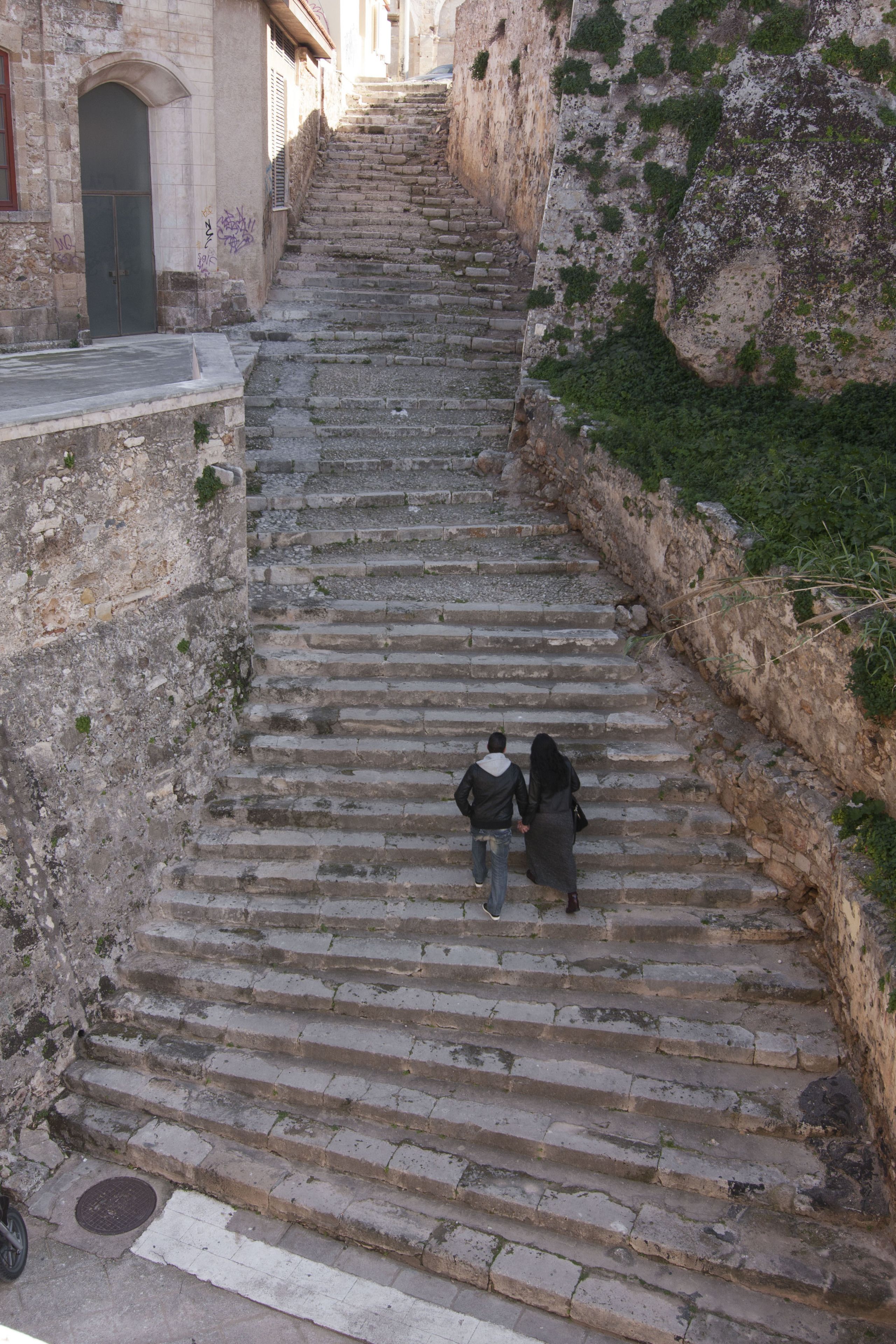 A set of stone steps leading up to a building with a door and windows.
