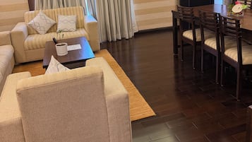 A modern living room with a sofa, coffee table, and dining area.