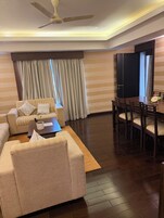 A modern living room with a sofa, coffee table, and dining area.