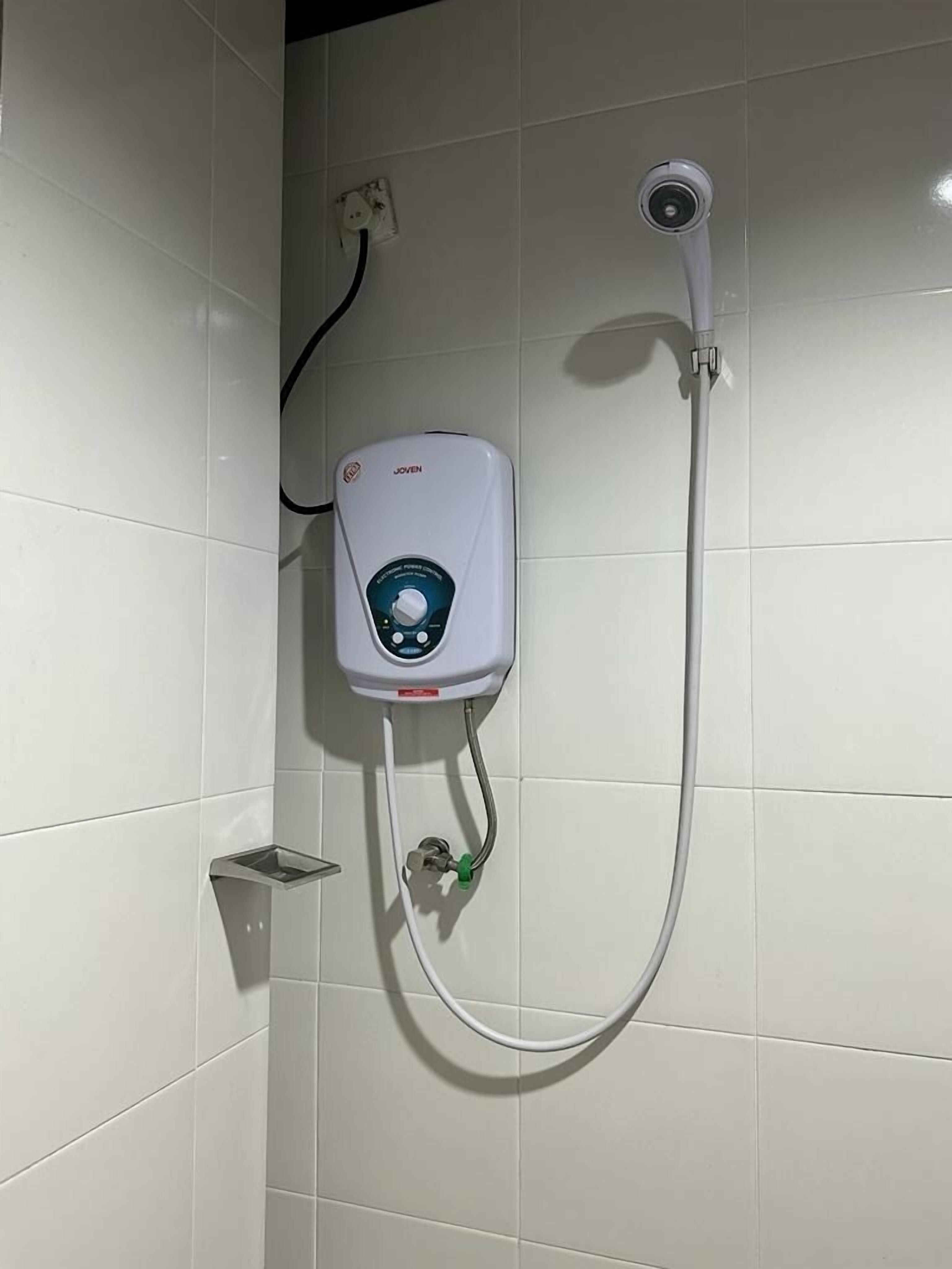 A shower unit with a control panel, a handheld showerhead, and a wall-mounted camera.