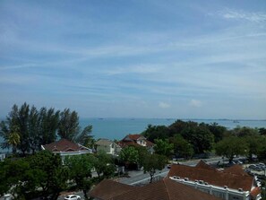 A coastal residential area with houses, a road, and a view of the sea. - Hotel Regal Malaysia (George Town)