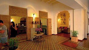 A spacious lobby with patterned flooring, wooden doors, and a seating area with cushions. - Thilanka Hotel (Kandy)