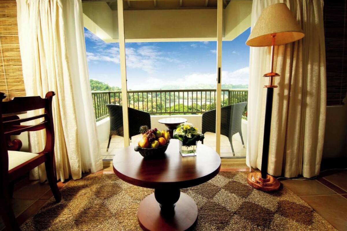 A balcony with a table, chairs, and a lamp.