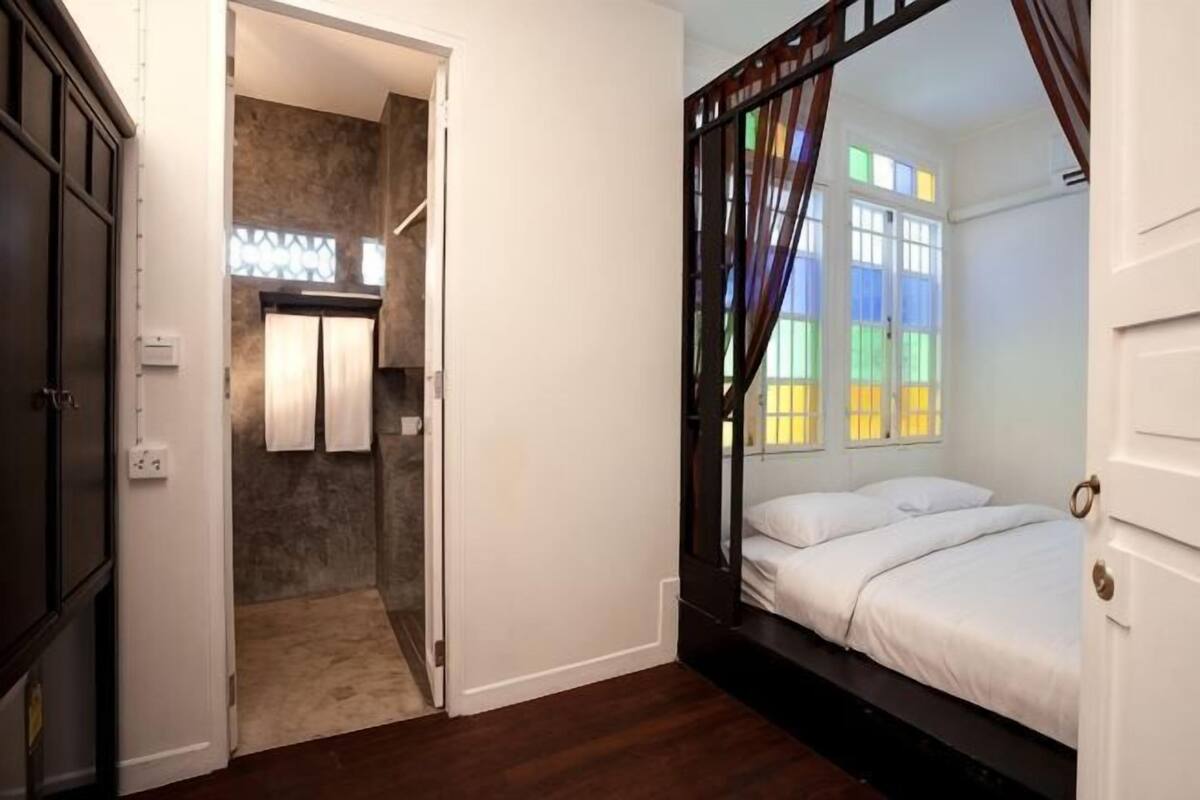 Une chambre à coucher avec un lit à baldaquin, un dressing et une vue sur l’extérieur par une fenêtre.