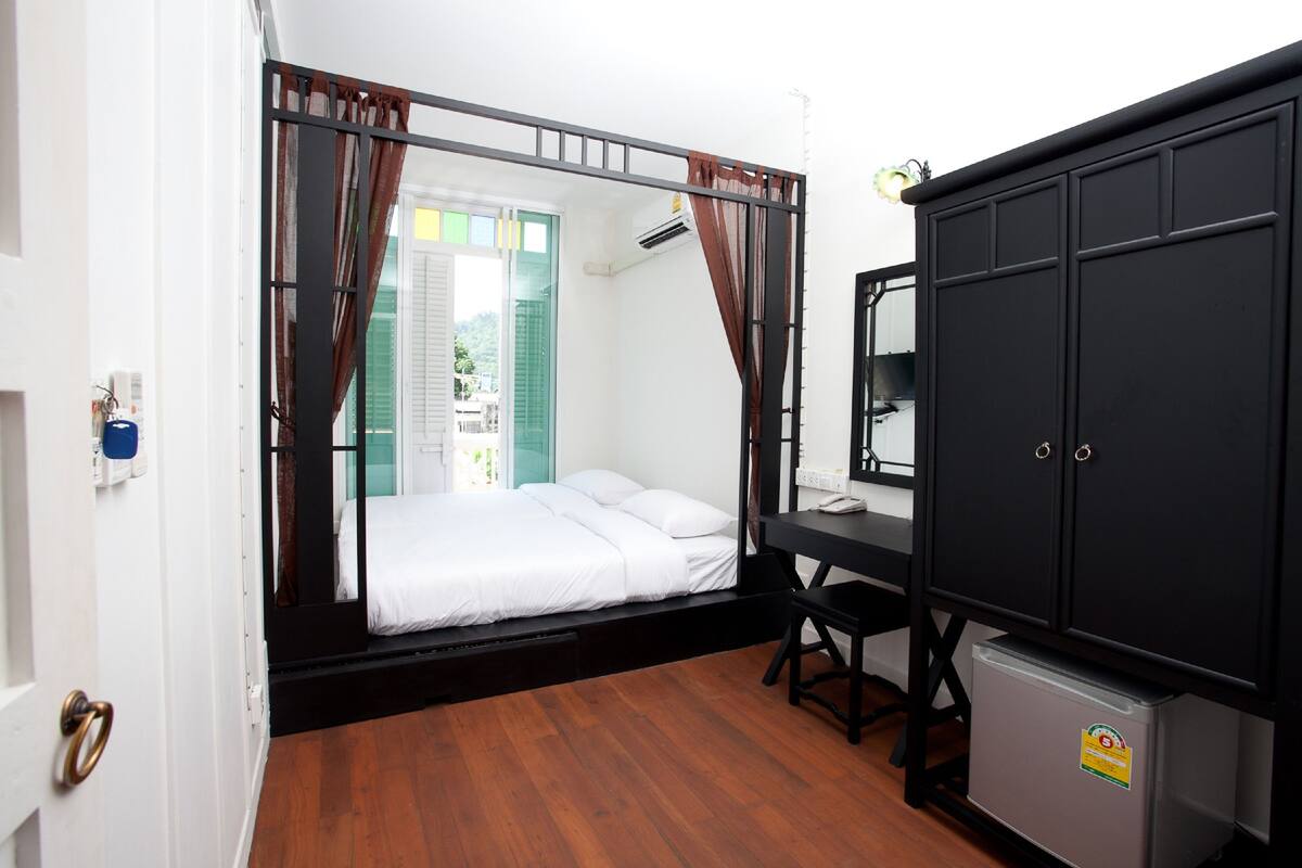 Une petite chambre comprenant un lit, un bureau et une armoire.