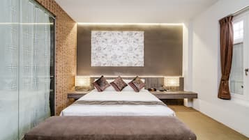 A modern bedroom with a large bed, a bedside table, a wall-mounted TV, and a window with curtains.