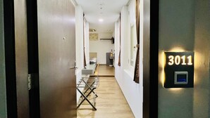 Un pasillo de hotel con un cartel de número, un escritorio y una silla.