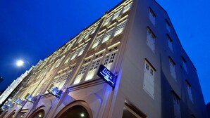 Un hotel de varios pisos con señalización iluminada y una entrada destacada.