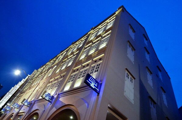 Un hotel de varios pisos con señalización iluminada y una entrada destacada.