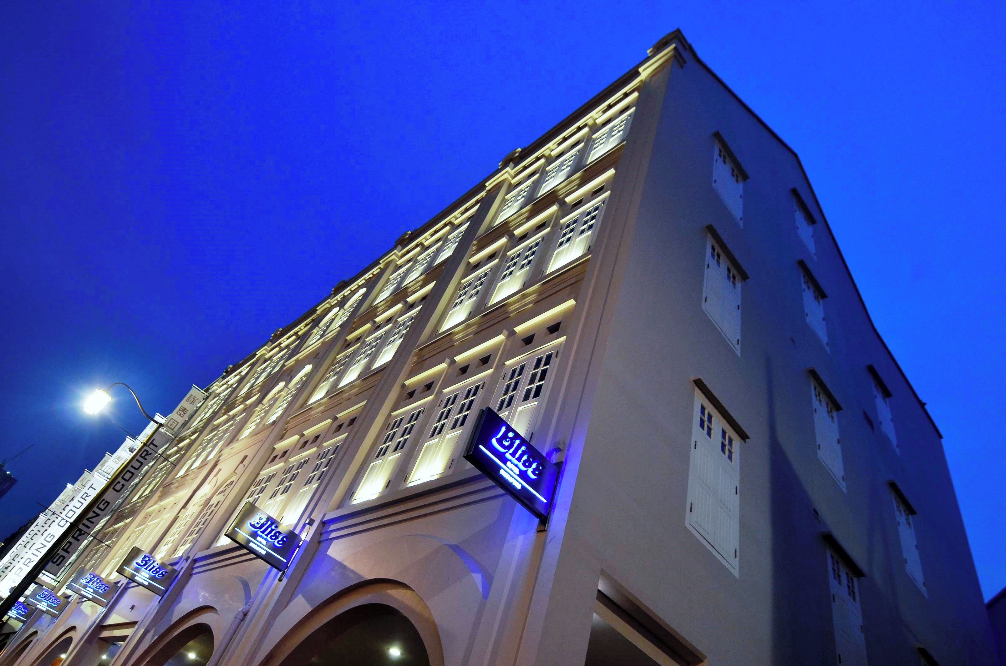 Ein mehrstöckiges Hotel mit beleuchteter Schilderung und einem markanten Eingang.