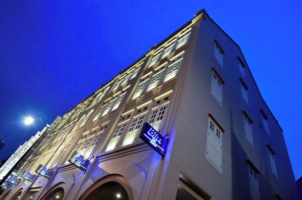 A multi-story hotel building with illuminated signage and a clear night sky.