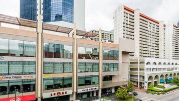 Un edificio de varios pisos con diversos comercios en la planta baja, incluyendo una agencia de viajes y un restaurante.