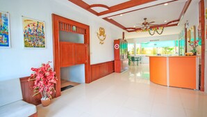 A spacious lobby with a reception desk, a ceiling fan, and a restaurant in the background. - Phuket Airport Sonwa Resort (Sa Khu)