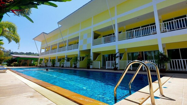 A hotel with a swimming pool, multiple balconies, and a tropical garden setting. - Phuket Airport Sonwa Resort (Sa Khu)