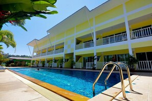 A hotel with a swimming pool, multiple balconies, and a tropical garden setting. - Phuket Airport Sonwa Resort (Sa Khu)