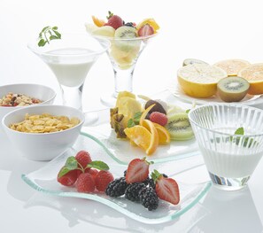 A variety of food items including fruits, yogurt, cereal, and a glass of milk arranged on a white surface. - Hotel Vischio Amagasaki  (Amagasaki)