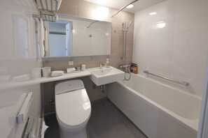 A modern bathroom with a toilet, sink, and bathtub. - Hotel Vischio Amagasaki  (Amagasaki)