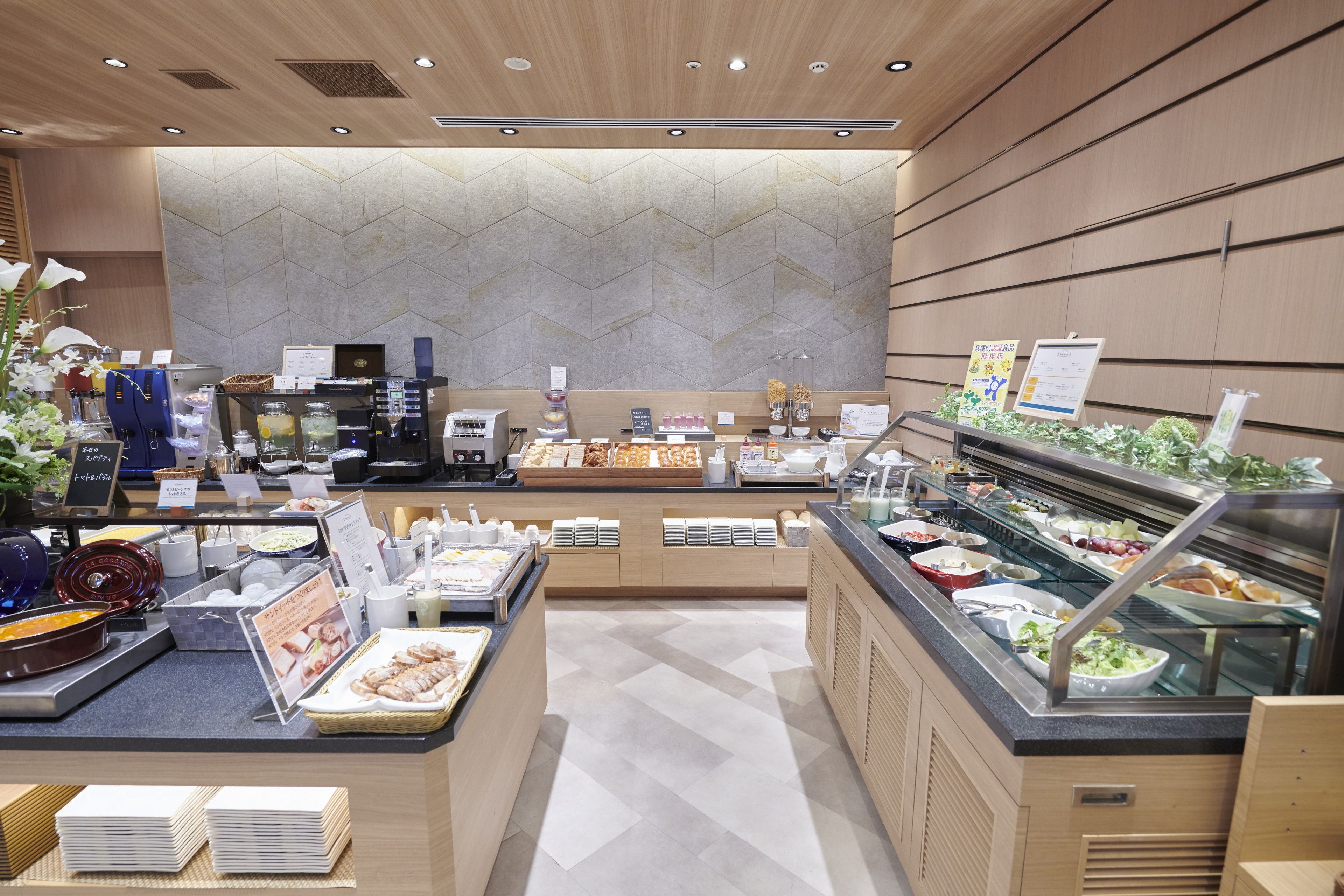 A buffet area with various food stations, a coffee machine, and a salad bar.