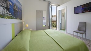 A hotel room with a bed, a chair, a TV, and a painting on the wall. - Bed & Breakfast Terrazze Villanova (Trapani)
