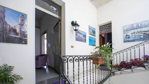 A staircase with a wrought iron railing, a purple chair, and potted plants. - Bed & Breakfast Terrazze Villanova (Trapani)